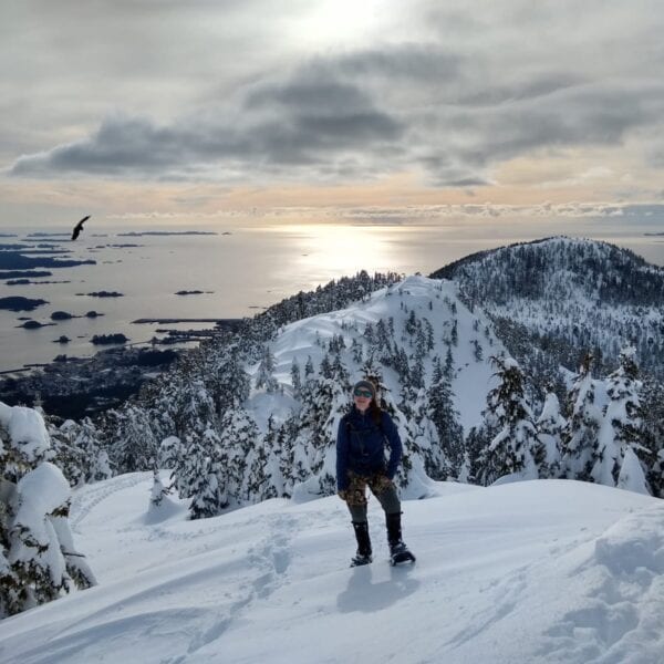 A hiker pauses in front of the Gavan Hill Trail, over a scenic overlook of Sitka Sound